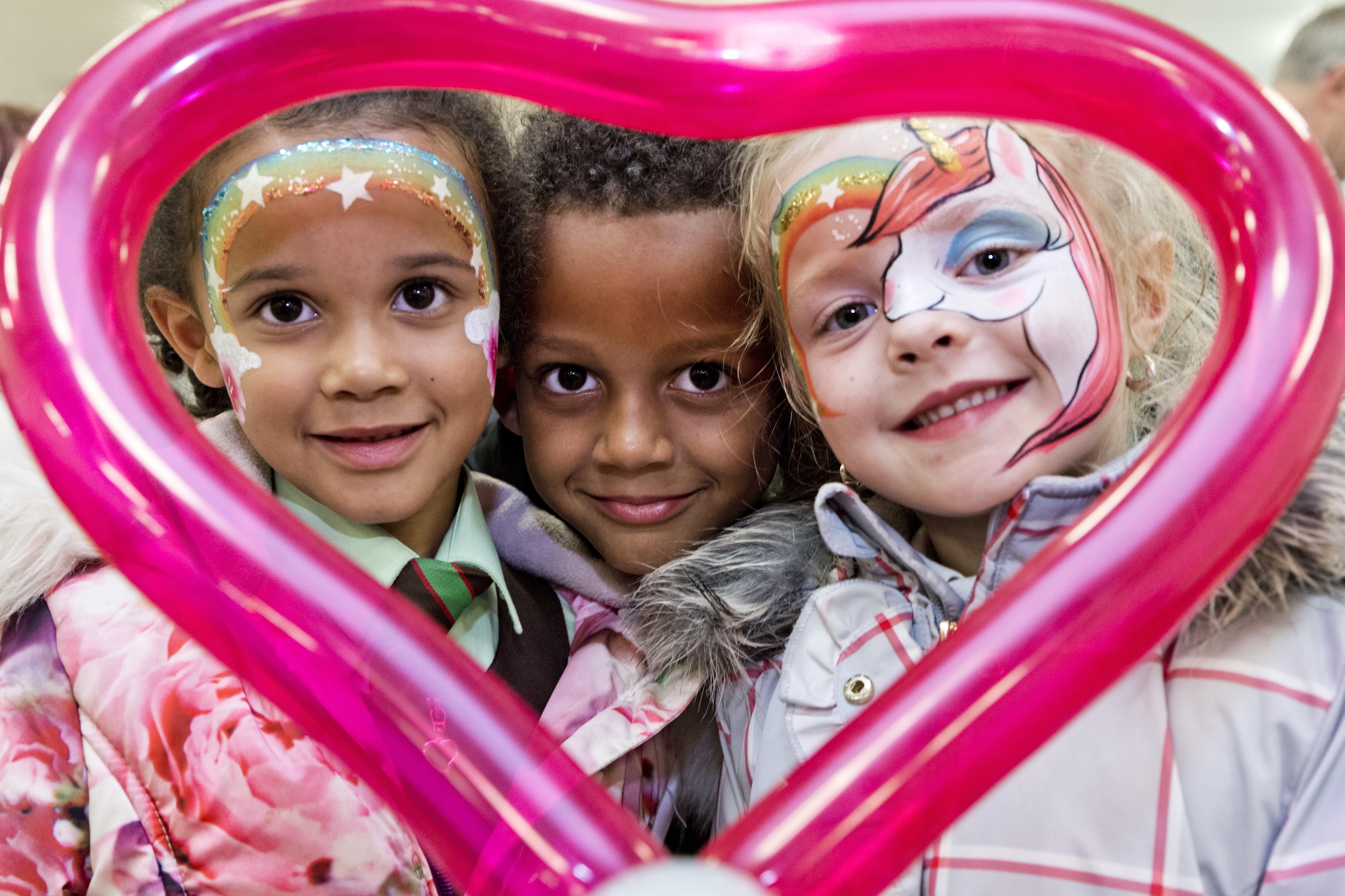  Young Kids Looking Through A Love Heart Ballon